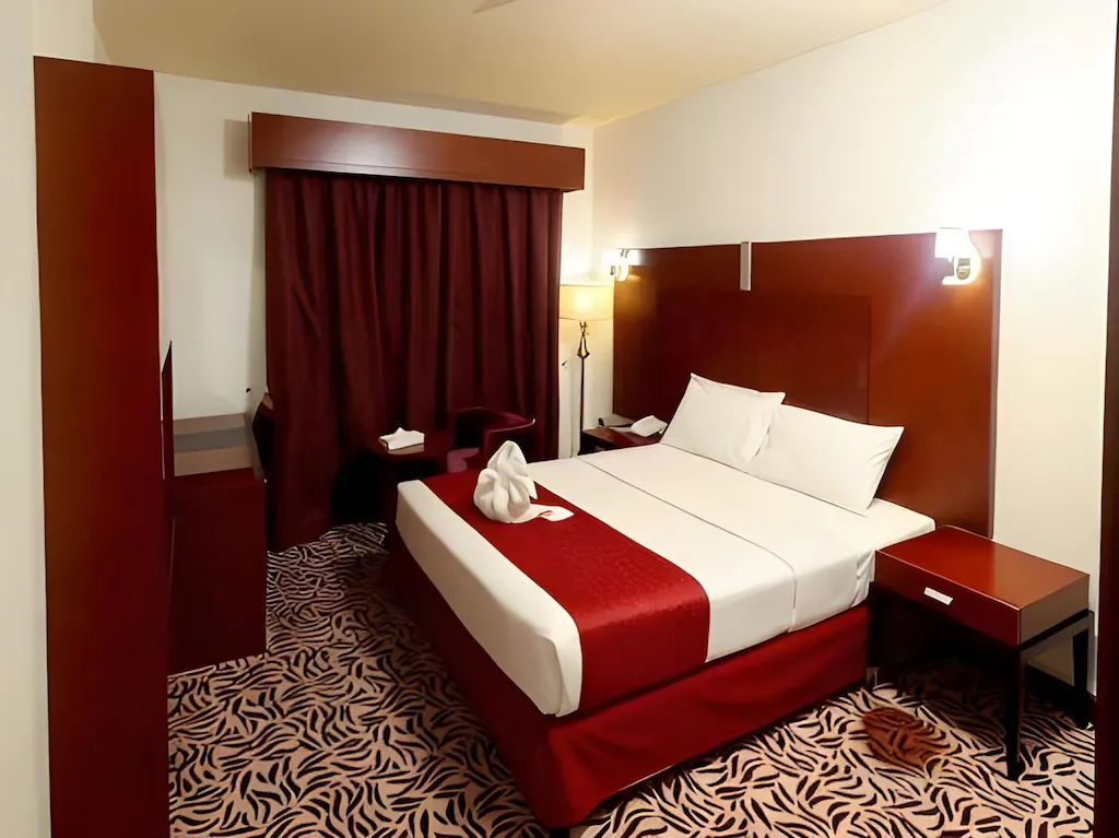 Guest room with double bed at MRA Grand Hotel, Dubai
